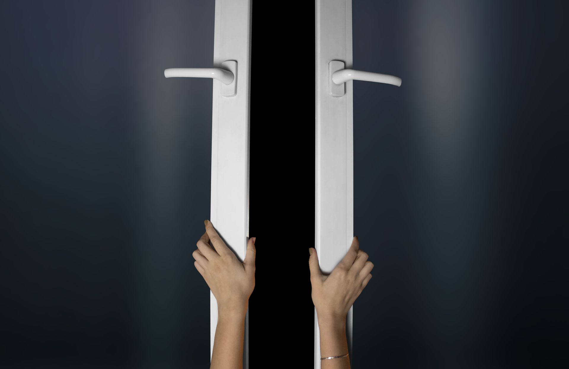 Hands opening modern vinyl replacement windows with white frames and secure handles indoors . Hands opening modern vinyl replacement windows with white frames and secure handles indoors .