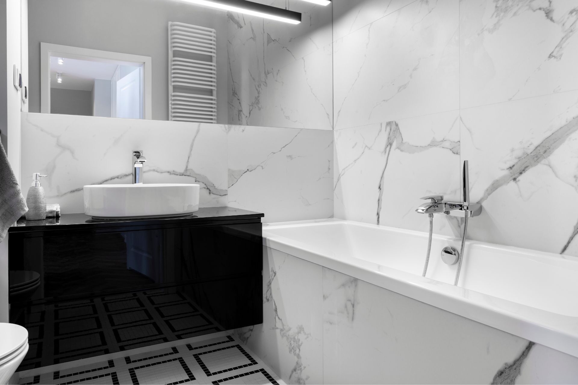 A bathroom with a bathtub , sink , toilet and mirror.