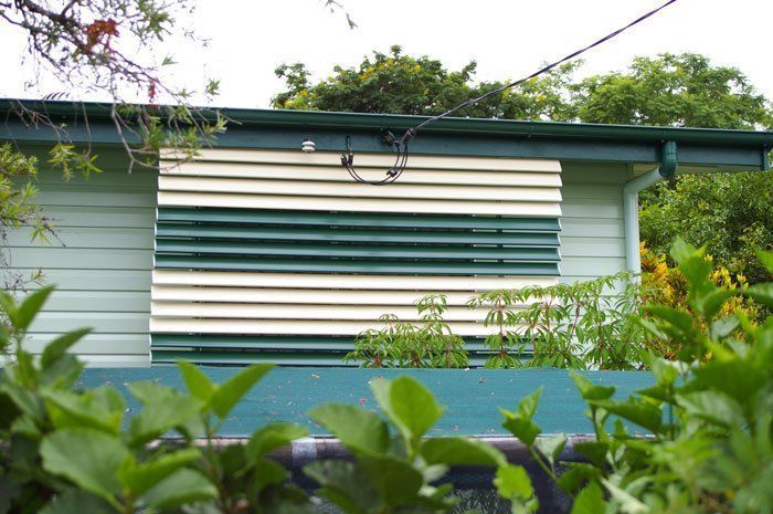 House With a Green and White Siding is Surrounded by Trees — Blind Outfitters in Brinsmead, QLD