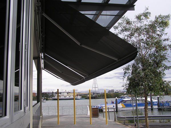 Black Awning is Hanging Over a Window Overlooking a Body of Water — Blind Outfitters in Atherton Tablelands, QLD
