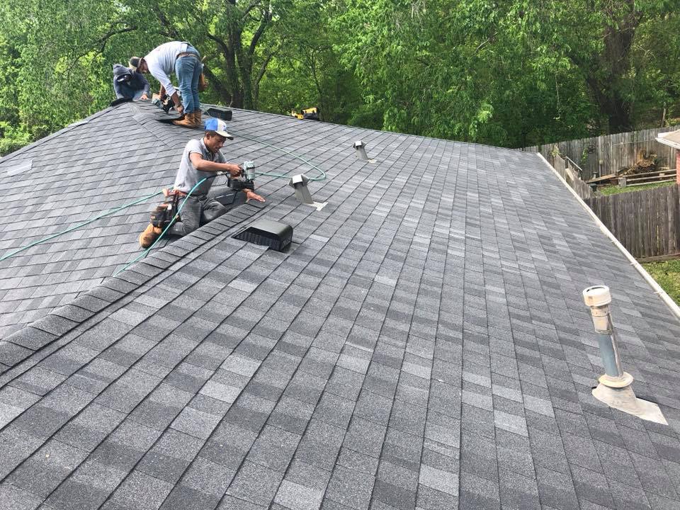 A group of men are working on a roof.