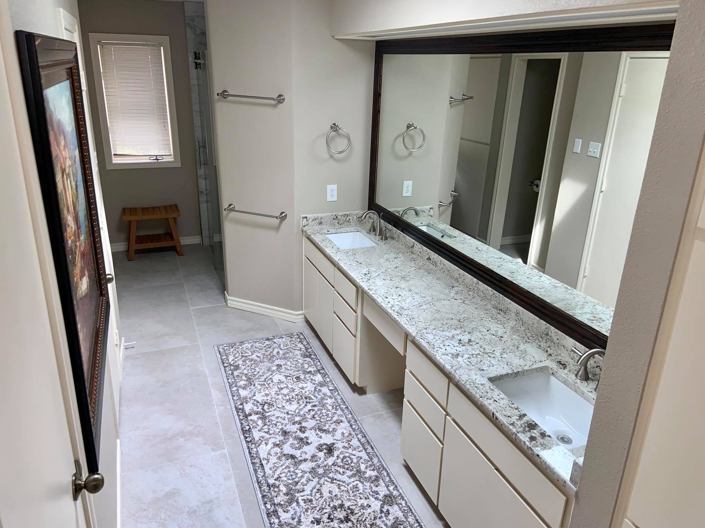 A bathroom with two sinks and a large mirror.