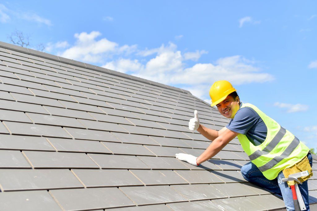 A man is working on the roof of a house.