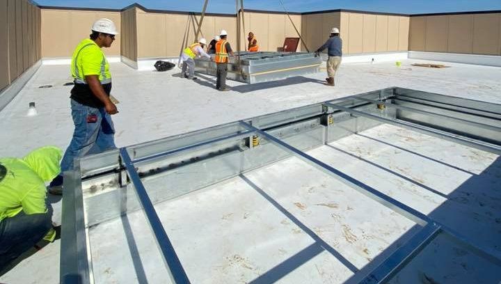 A group of construction workers are working on a roof