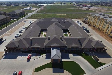 An aerial view of a large building with cars parked in front of it