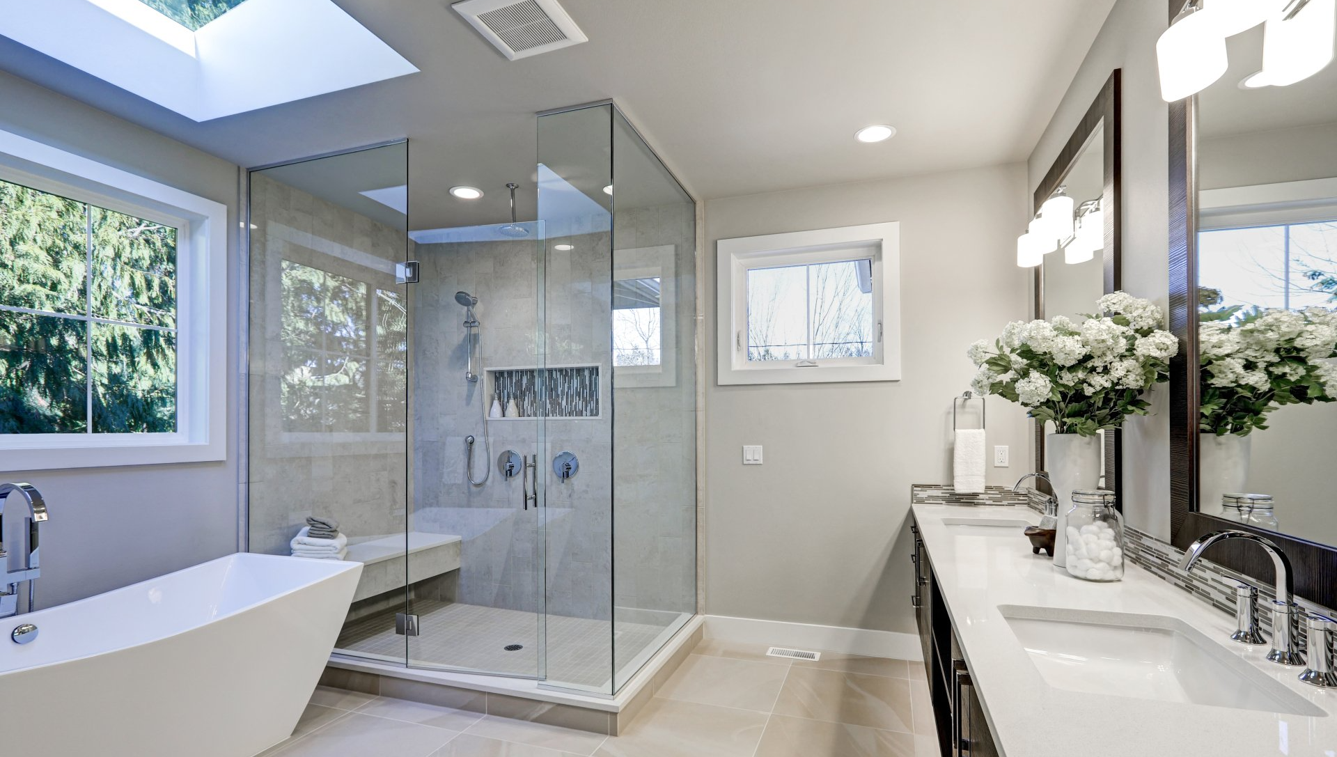A bathroom with two sinks , a tub , and a walk in shower.