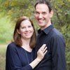 A man and a woman are standing next to each other and smiling for a picture.