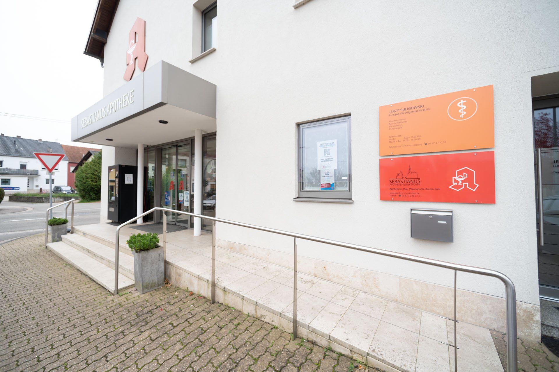 Ein weißes Gebäude mit einem roten Schild an der Seite.