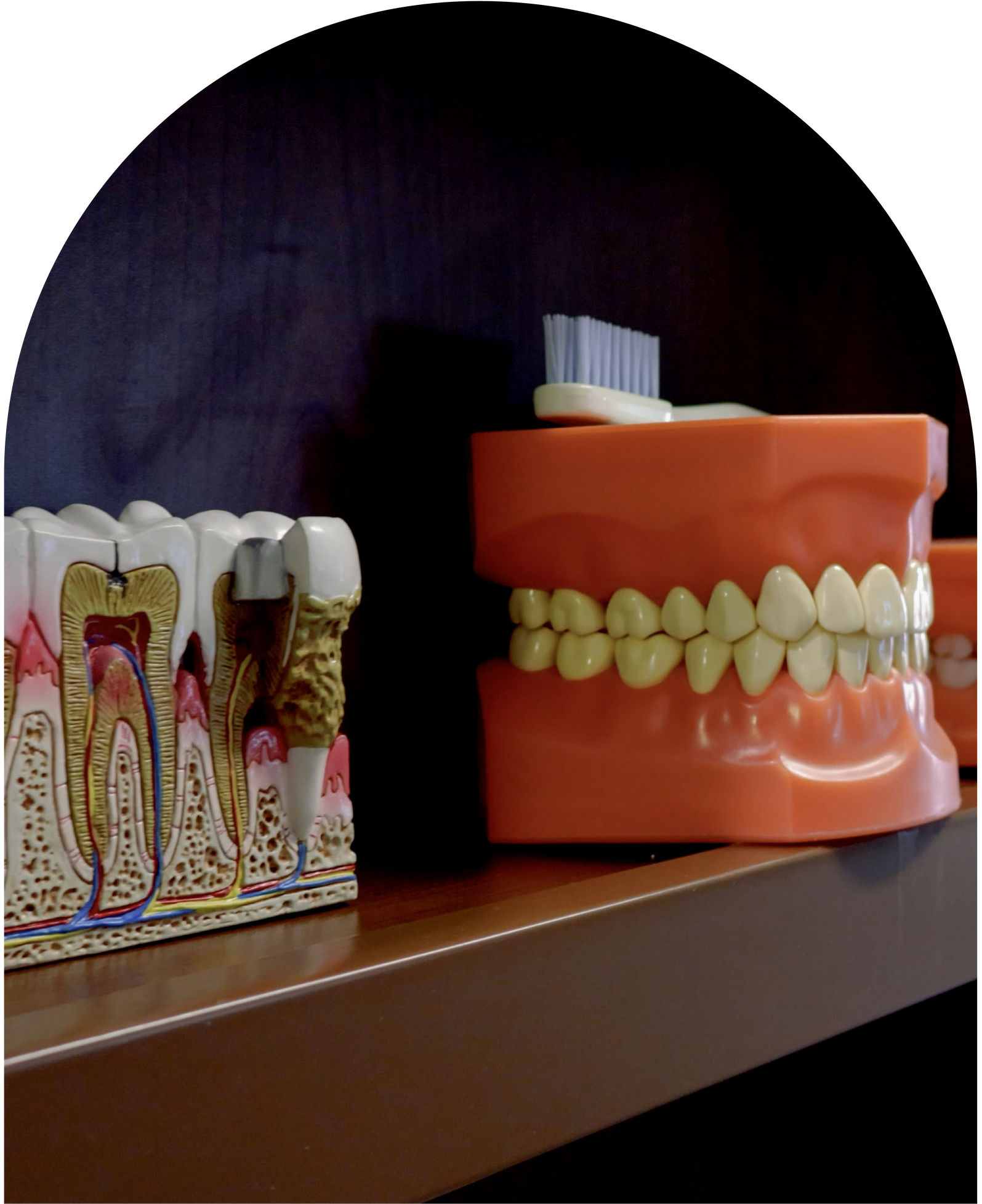 Woman holding toothbrush, touching jaw, appears to be experiencing tooth pain, in a bathroom in Hunt Valley, MD, 21030.