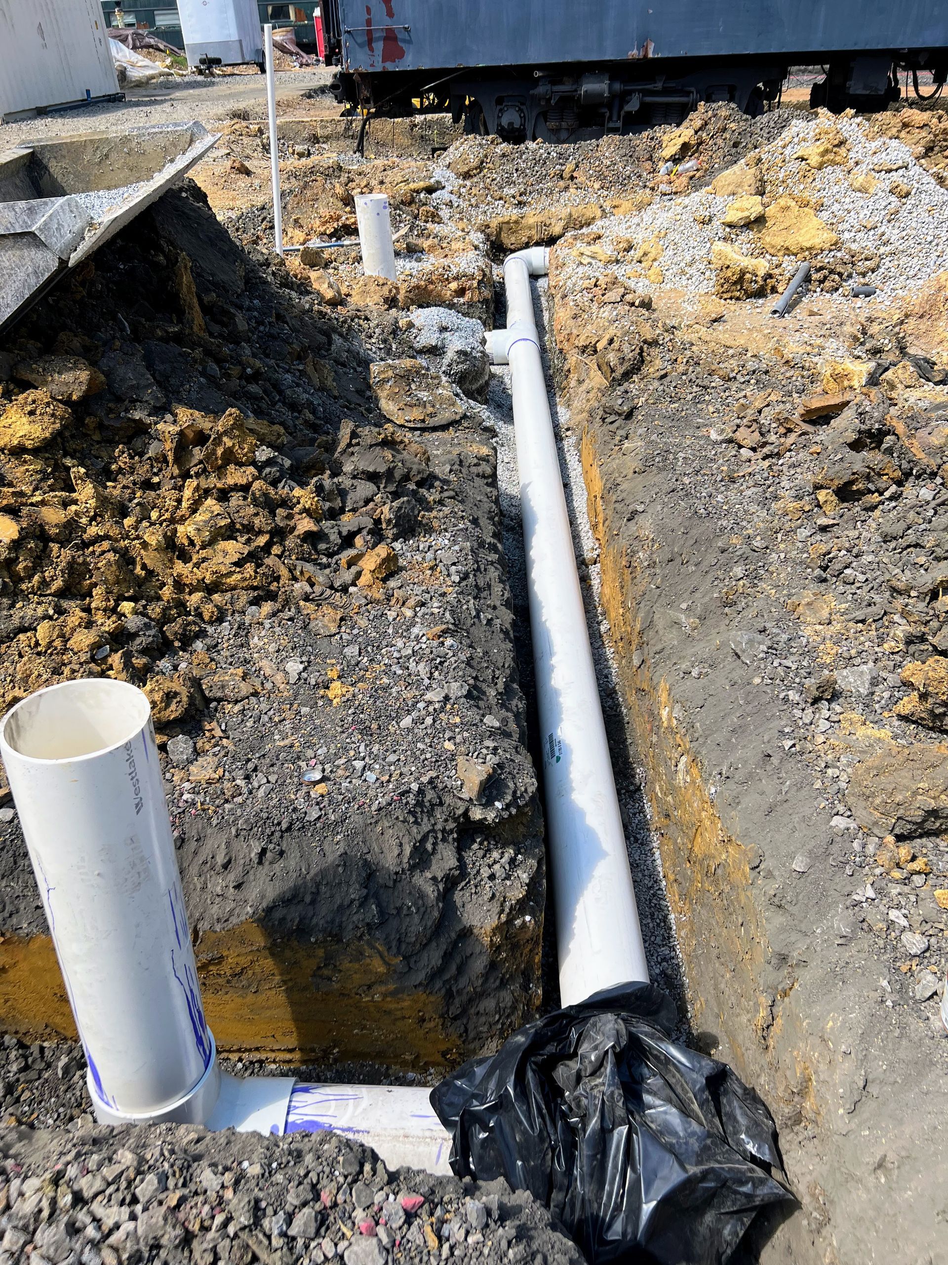 A toolbox is sitting on top of a pile of dirt next to a hole in the ground.
