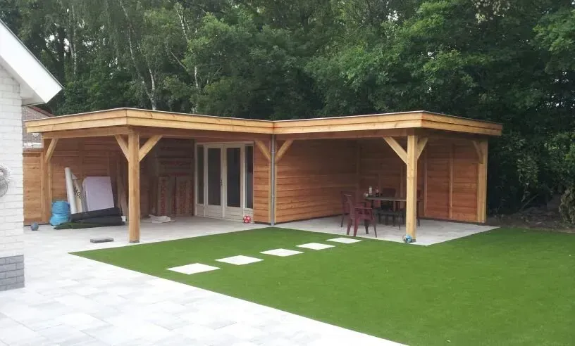 Een achtertuin met een houten constructie en een tafel en stoelen