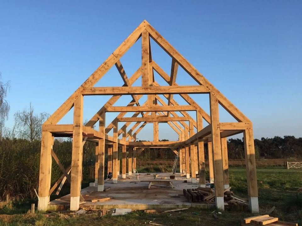 In een veld wordt een groot houten bouwwerk gebouwd