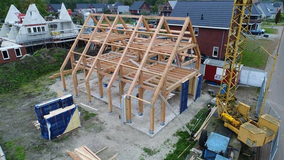Een luchtfoto van een gebouw in aanbouw met een kraan op de achtergrond.