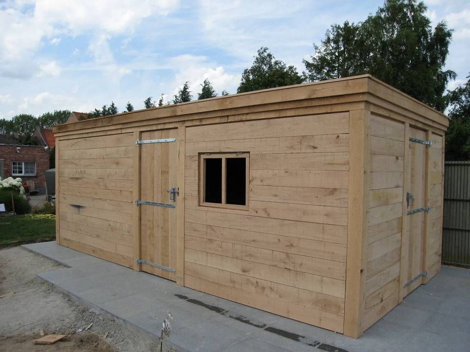 Een houten schuur met twee deuren en een raam