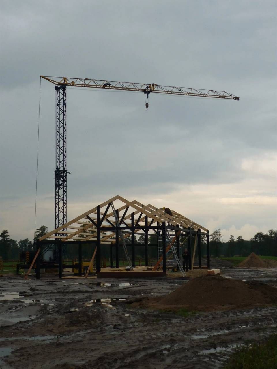 Een gebouw in aanbouw met een kraan op de achtergrond