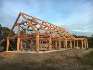Bovenop een zandheuvel wordt een groot houten bouwwerk gebouwd.