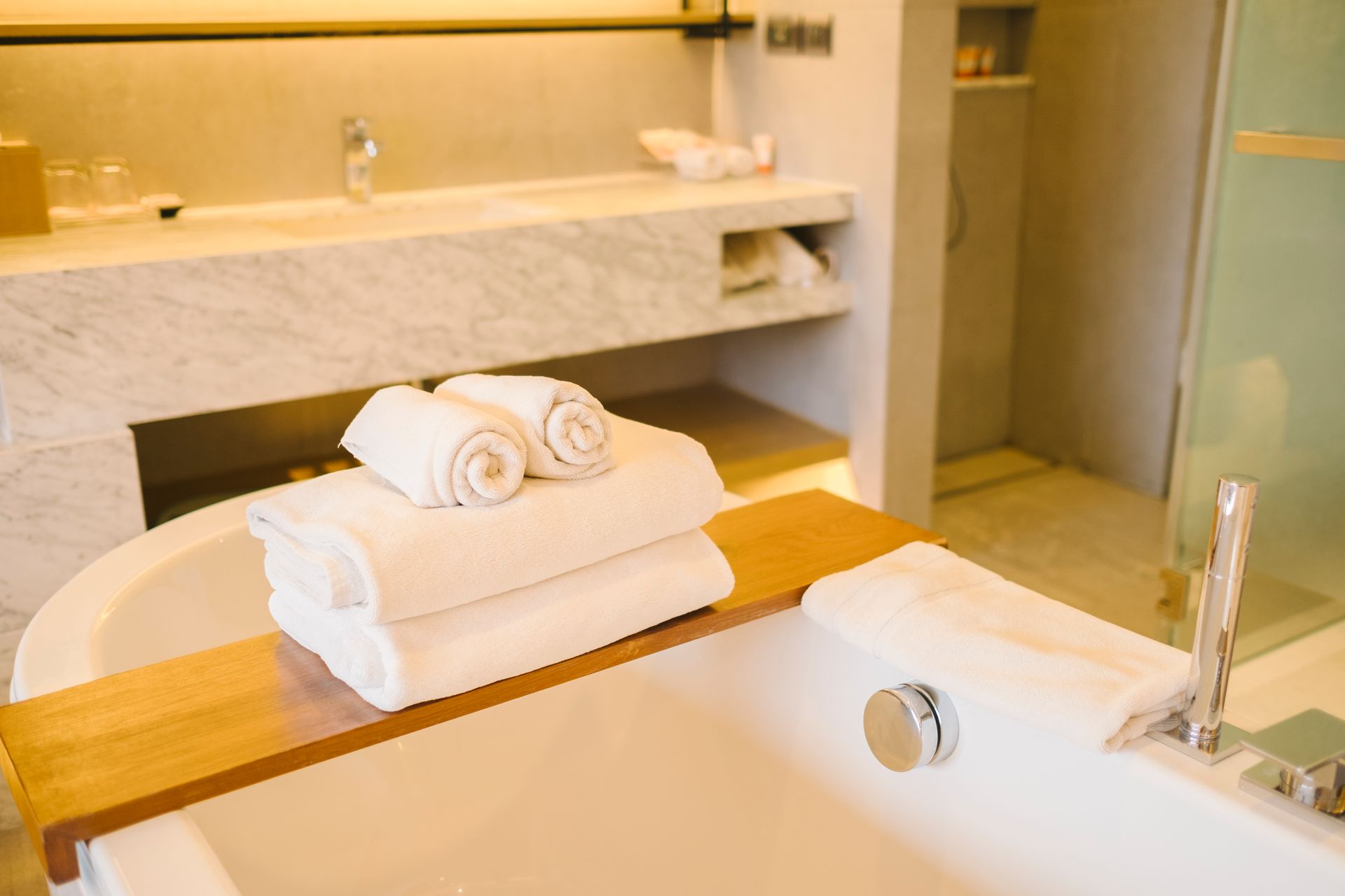 Modern bathroom with bathtub, folded white towels, and a vanity sink
