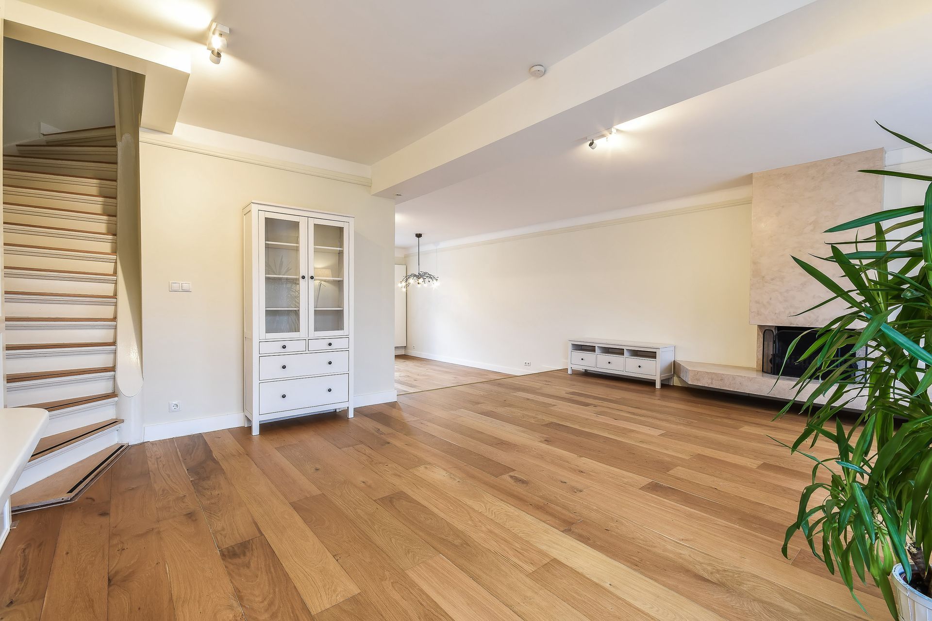 a living room with hardwood floors and a staircase