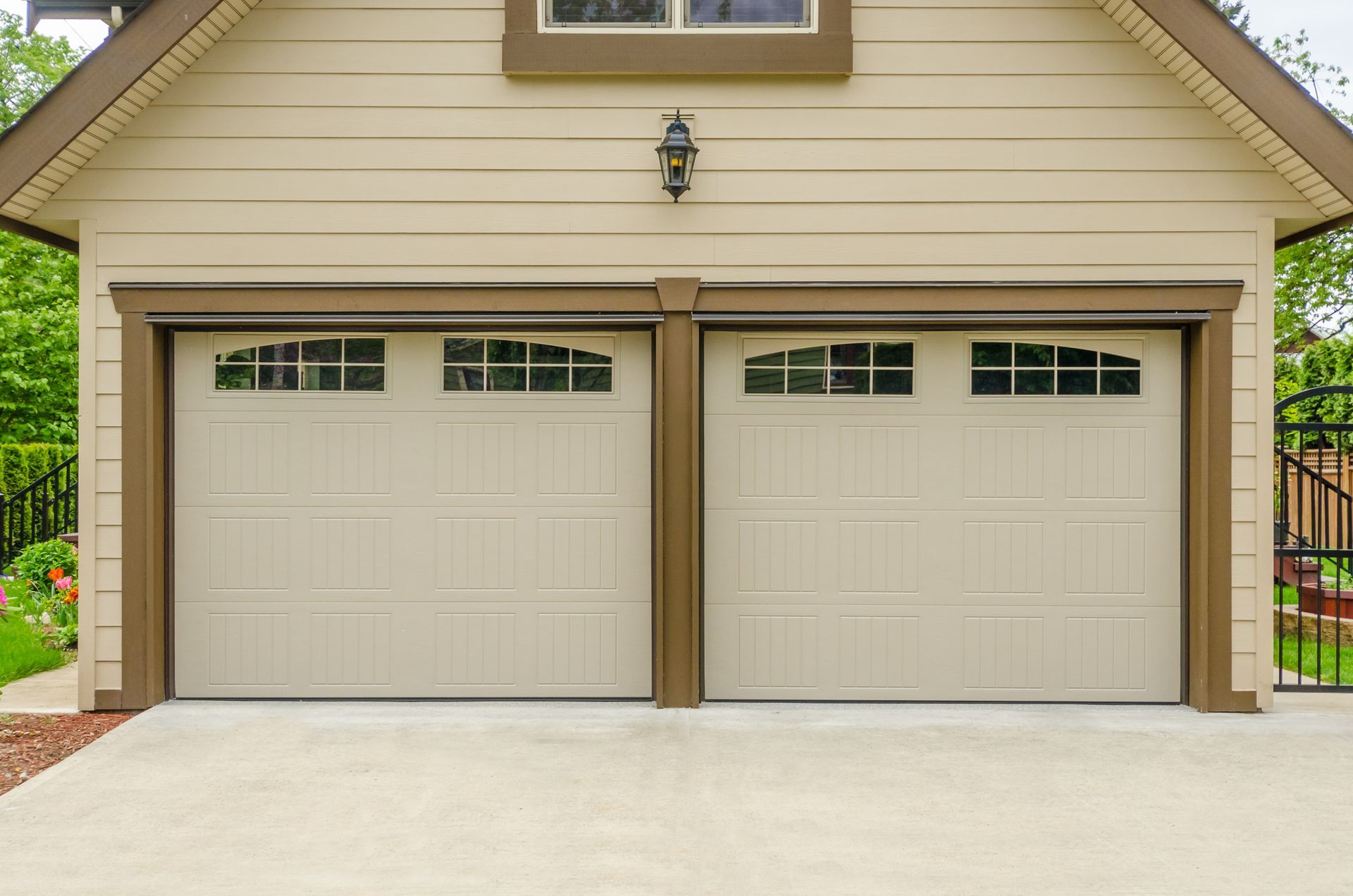 a beige garage door with a lantern on top of it