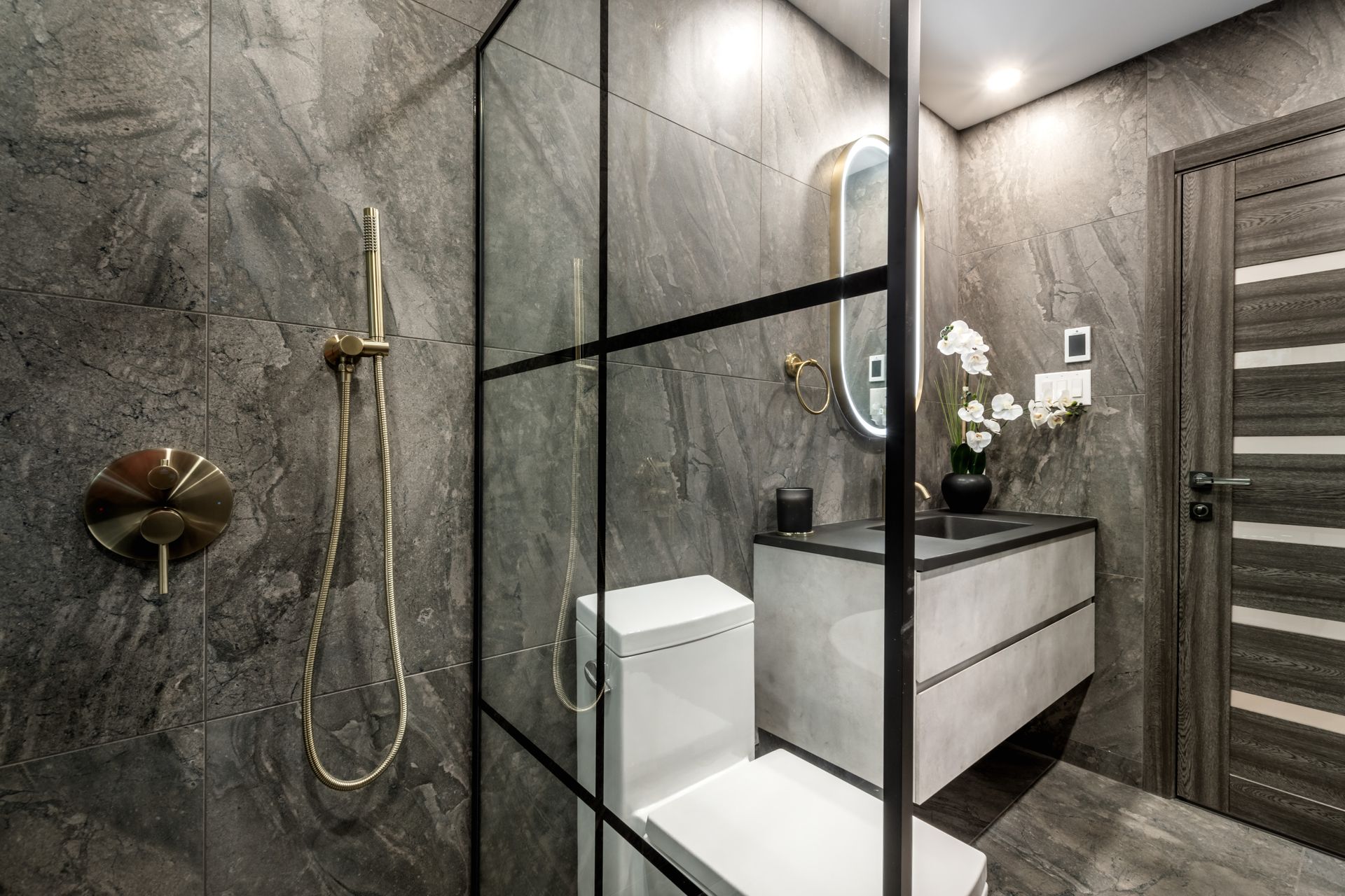 Modern bathroom with black vanity, two mirrors, and a glass-enclosed shower.