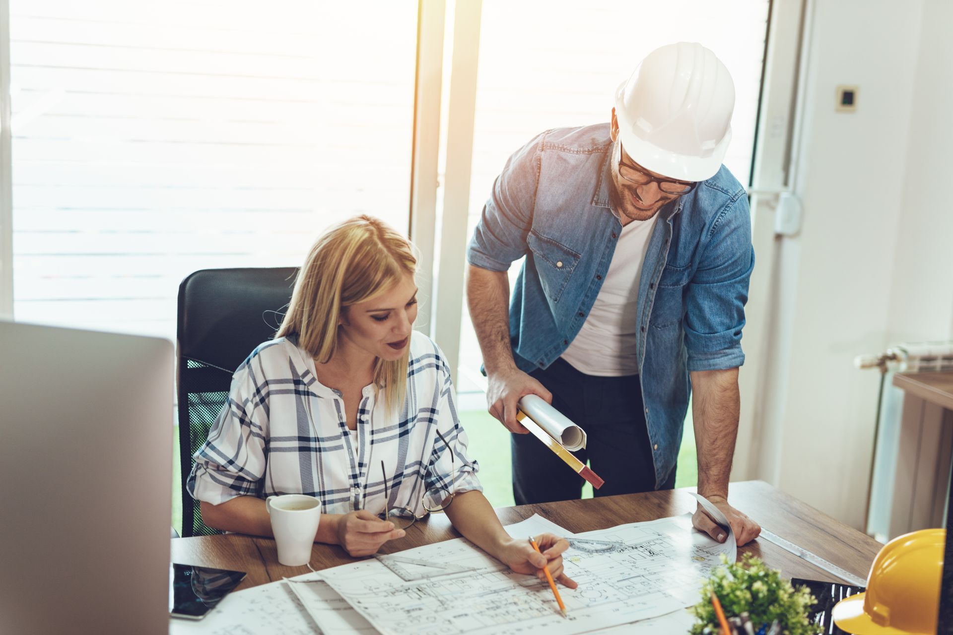 a man and a woman are looking at a blueprint together