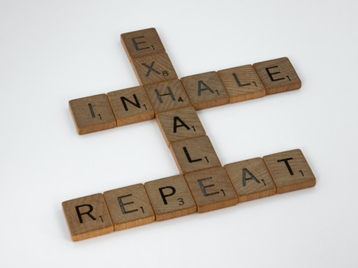 Scrabble tiles spelling out the words exhale and repeat
