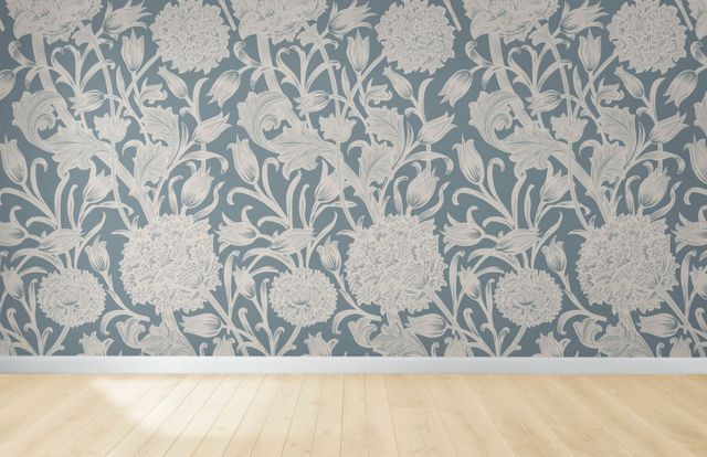 Light blue floral wallpaper above light wood floor.