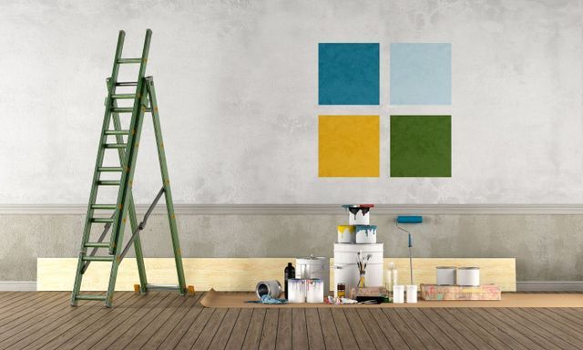 Green ladder, paint swatches, and painting supplies in a room, ready for a paint job.