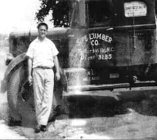 A person stands beside a parked Sipe Lumber Co. delivery truck in Taylorsville, N.C.