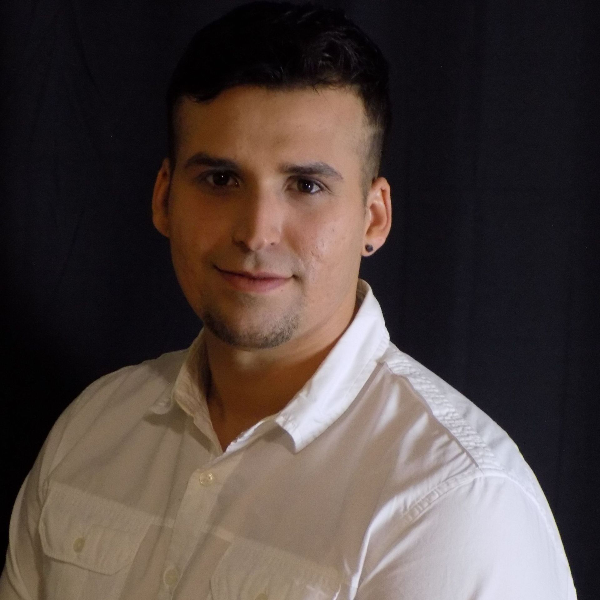 A man in a white shirt is smiling for the camera