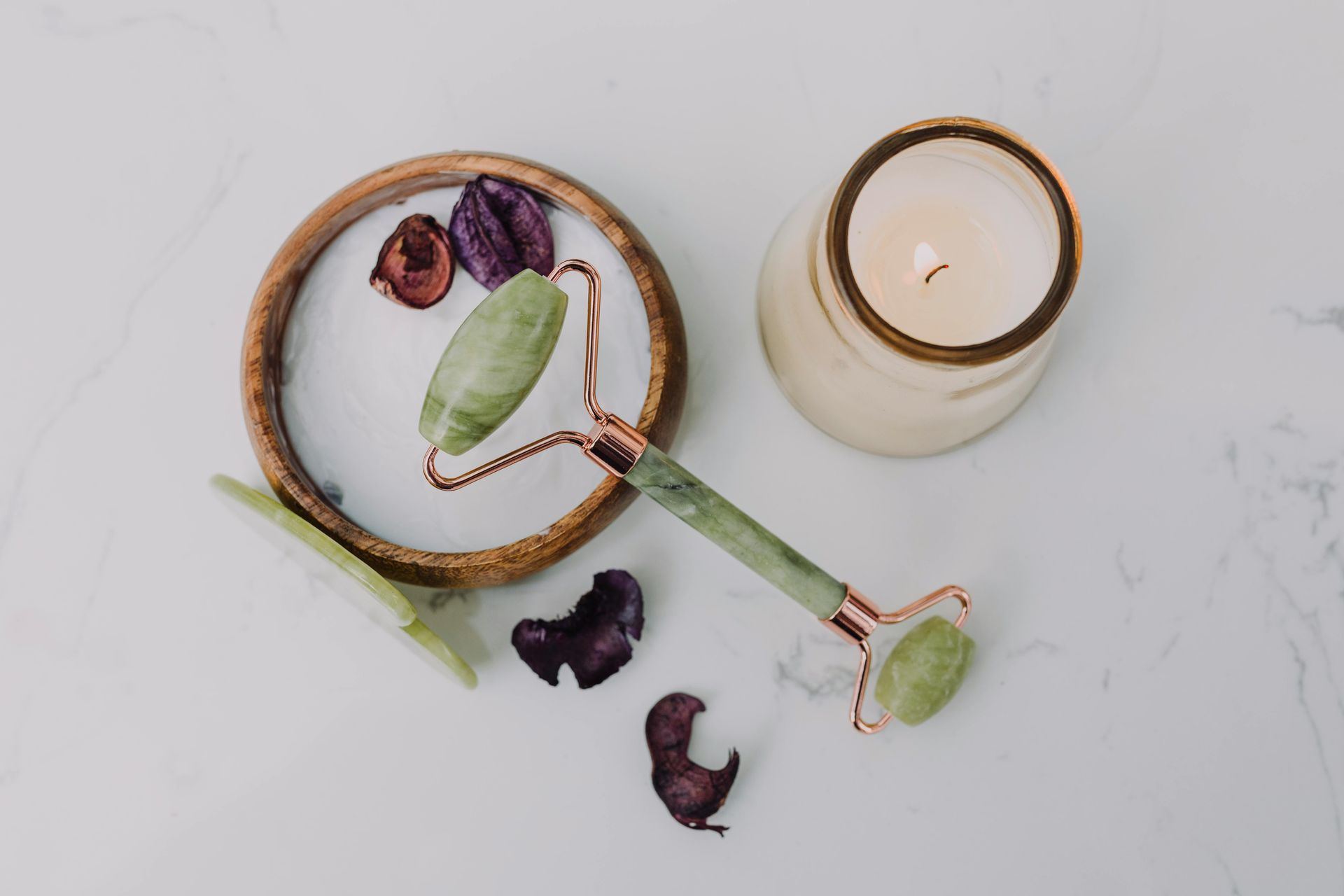 Two cups of herbal tea with dried leaves and petals on a white marble surface