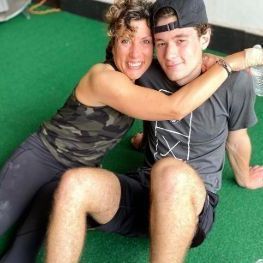 A man and a woman are sitting on the floor hugging each other.