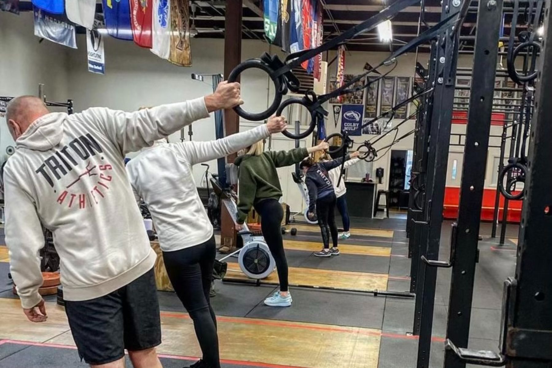 A man and a woman are holding rings in a gym.