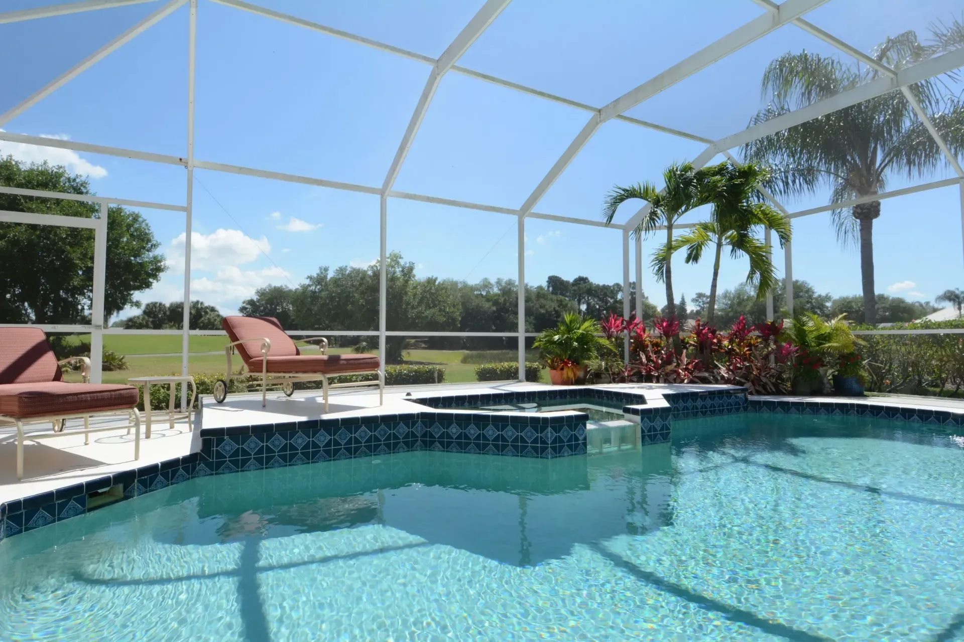 A swimming pool with a screened in area and steps leading to it.