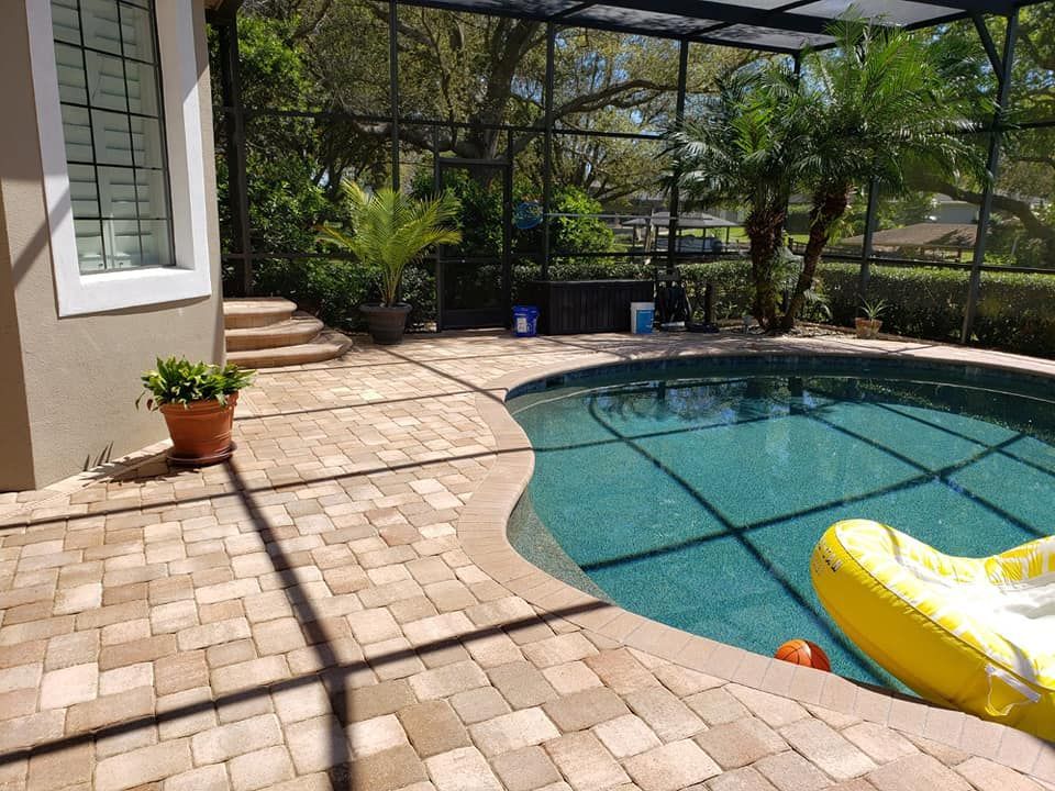 A brick paver driveway leading to a white house in sebastian florida.