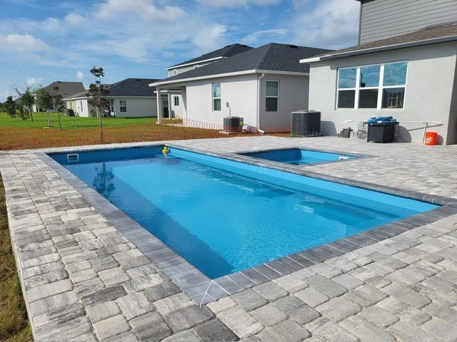 Screened-in pool area with a curved pool, and paver patio