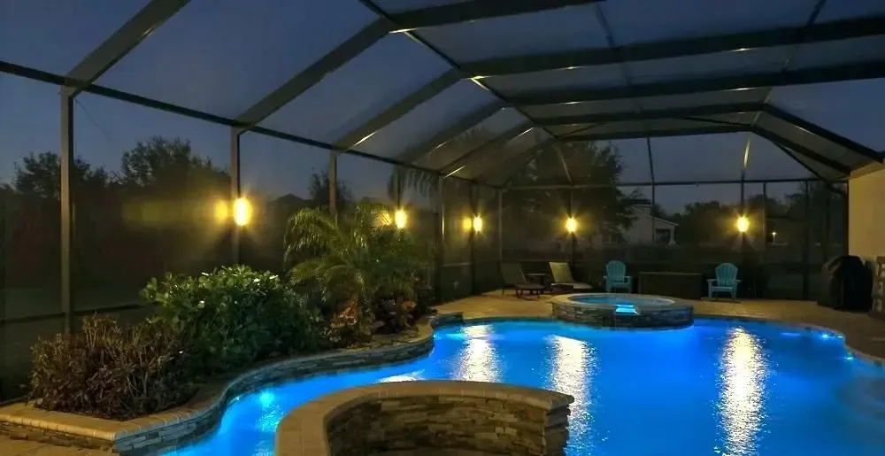 A swimming pool with a screened in area and steps leading to it.
