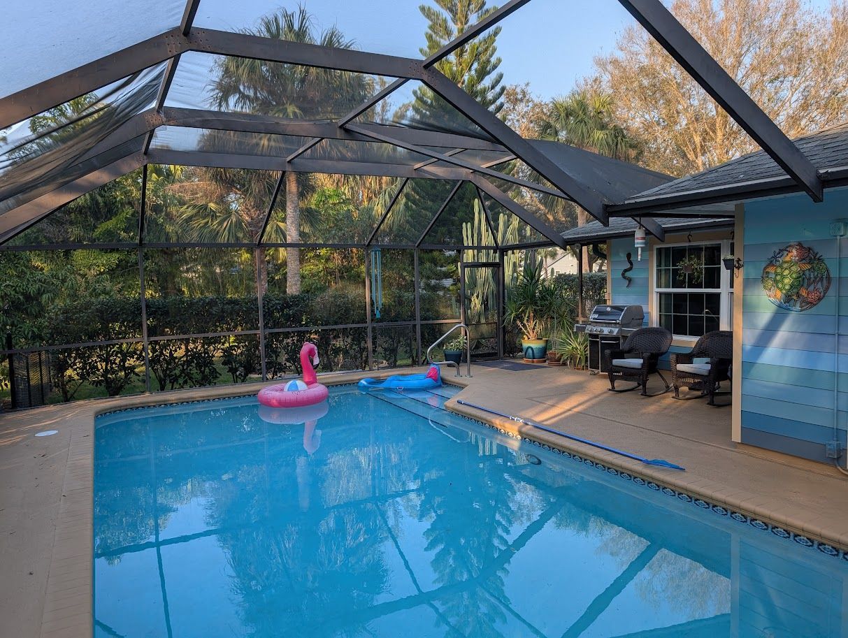 A swimming pool with a screened in area and steps leading to it.