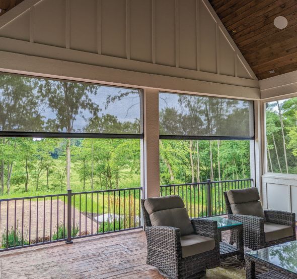 A screened in porch with a swimming pool in the background