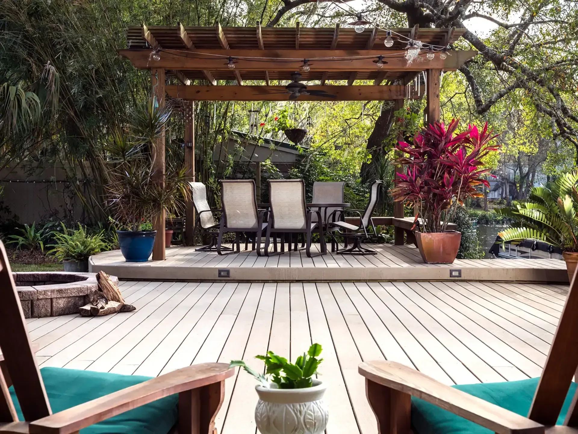 Two people sitting on the edge of an above-ground pool in a backyard patio area