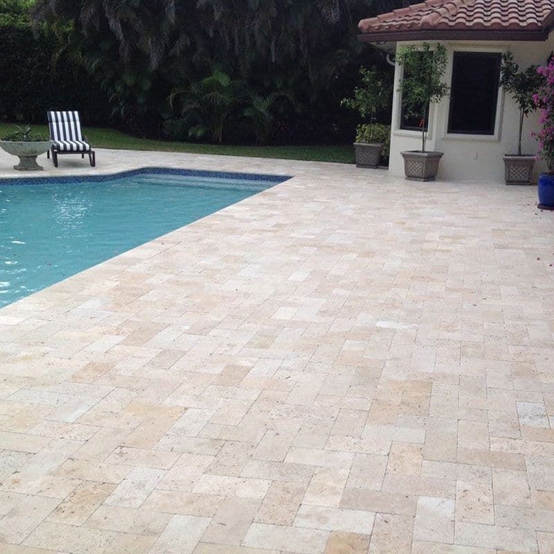 A screened in porch with a swimming pool in the background