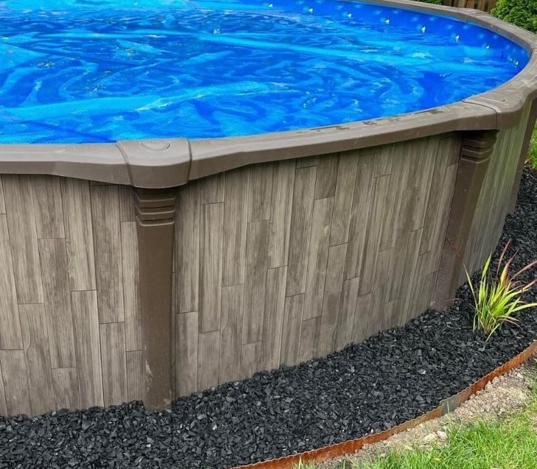 Wood-grain resin above-ground pool wall built by Right Way Enclosures, the rust-proof build used on salt-air Volusia lots