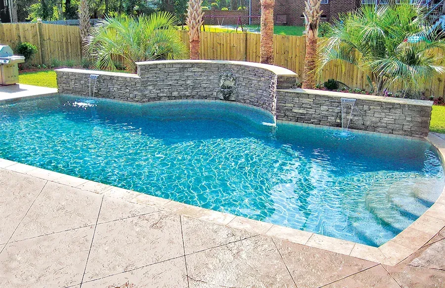Custom concrete pool with a natural stone waterfall at an Indian River County, Florida home