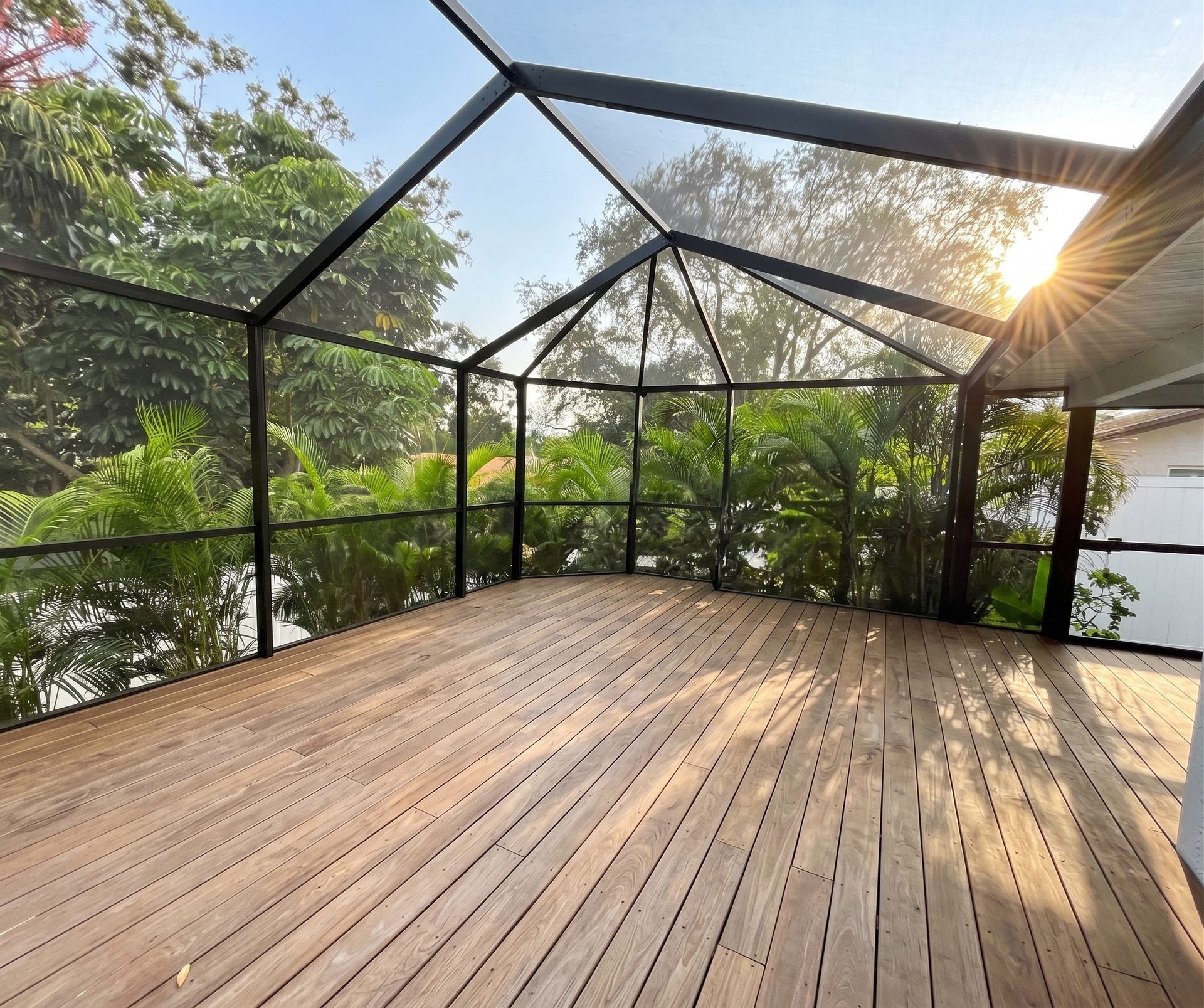 Screened-in backyard pool with blue water, wooden deck, and lounge chairs in the sun