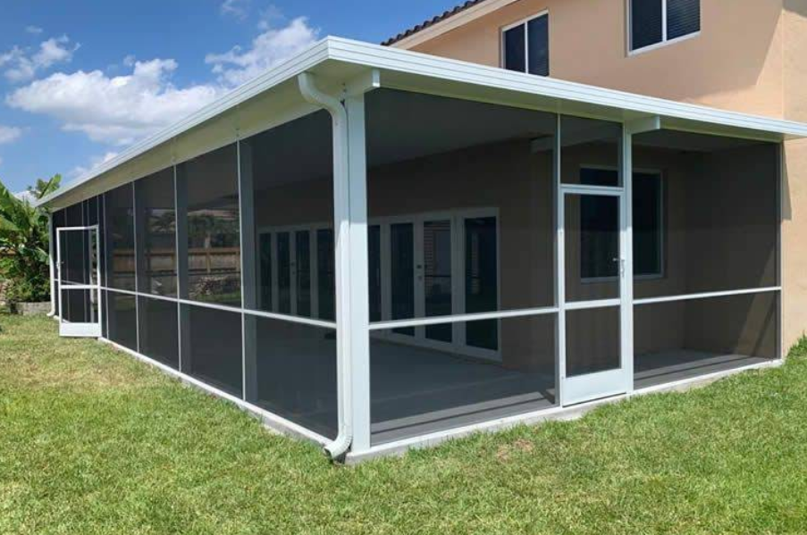 Screened-in patio on a beige house with white trim and green lawn.