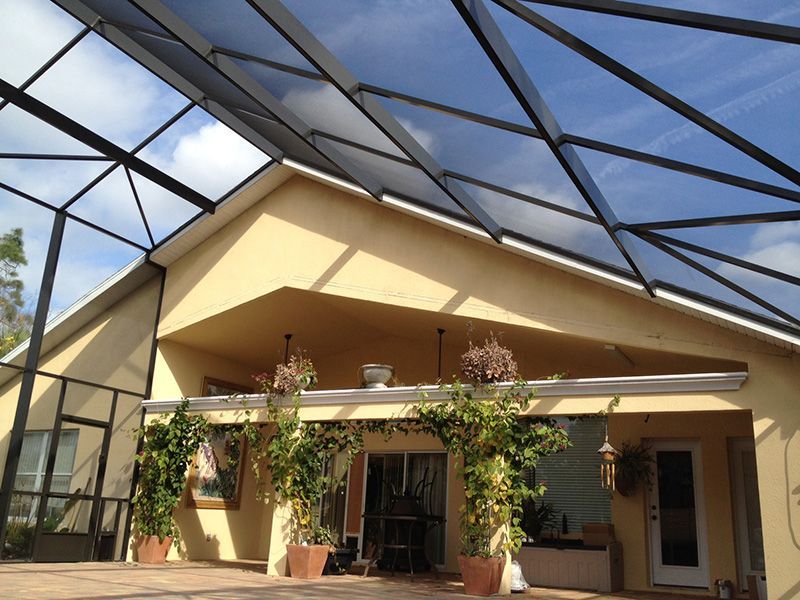 A screened in porch with a swimming pool in the background