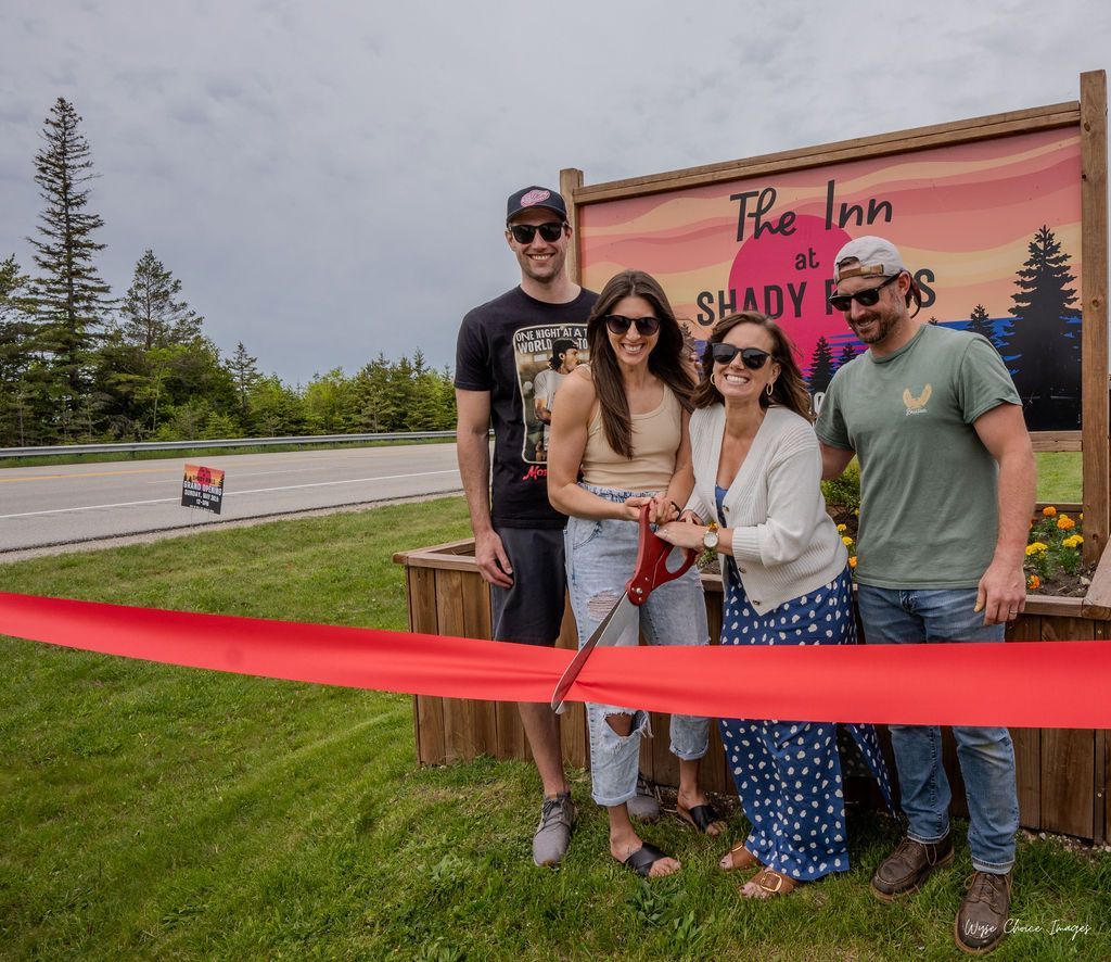 Ribbon cutting in front of a sign that reads 