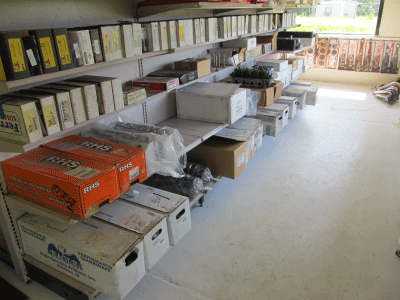 Boxes and crates stacked along shelves in a warehouse aisle