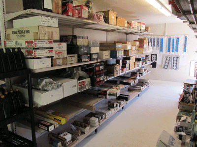 Long aisle of a store or warehouse with metal shelves stocked with boxes and supplies.
