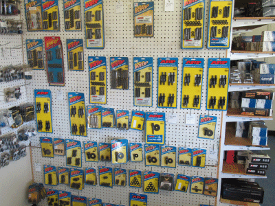 Store display of assorted packaged tools and hardware on pegboard shelves with yellow and blue packaging